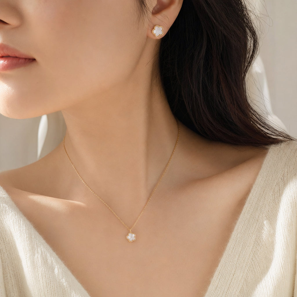 White clover pendant necklace and stud earrings worn, gold finish
