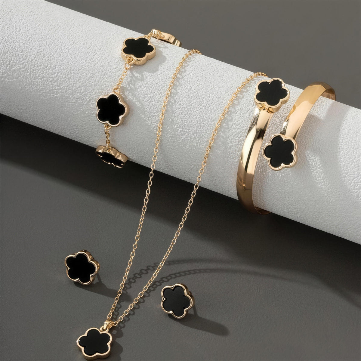 Black clover jewelry set on display, gold finish